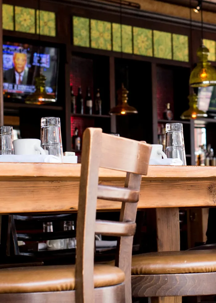 Wooden chairs with leather seats along a communal bar table