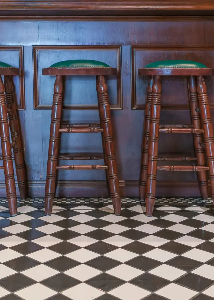 Bar stools standing on a checkerboard tile floor